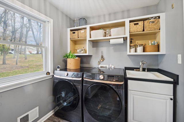 washroom with separate washer and dryer, plenty of natural light, cabinets, and sink