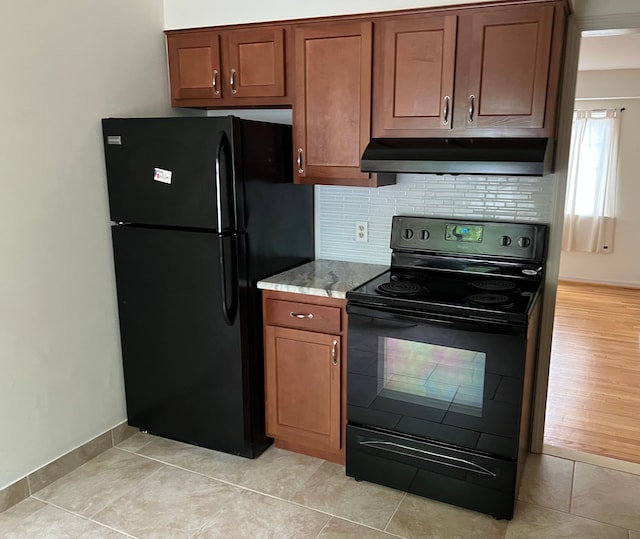 kitchen featuring ventilation hood, decorative backsplash, black appliances, and light hardwood / wood-style flooring