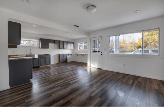 unfurnished living room featuring dark hardwood / wood-style flooring and sink