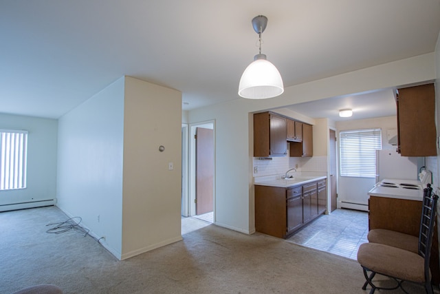 kitchen featuring pendant lighting, sink, decorative backsplash, baseboard heating, and light colored carpet