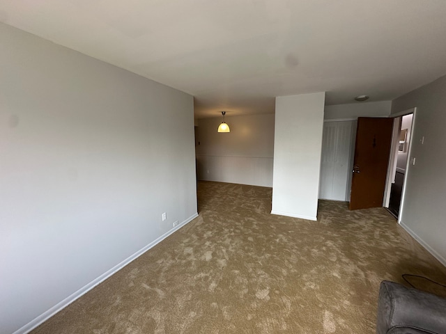 carpeted empty room featuring baseboards