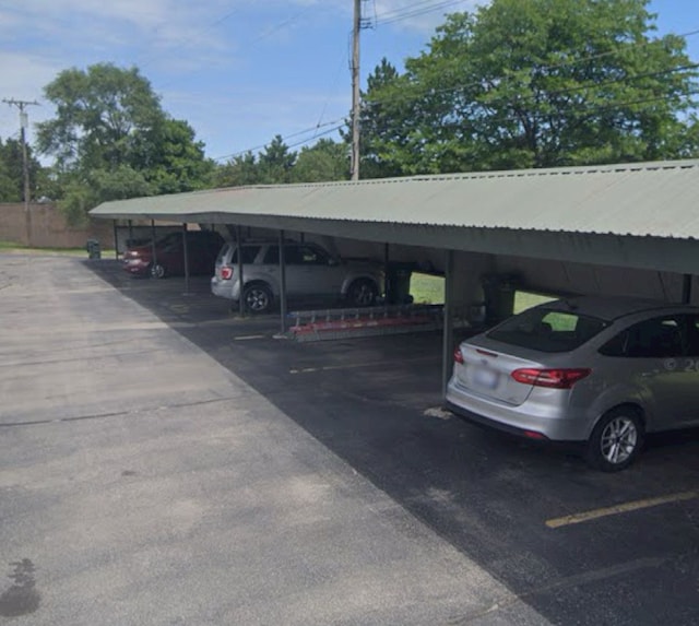 covered parking lot featuring fence