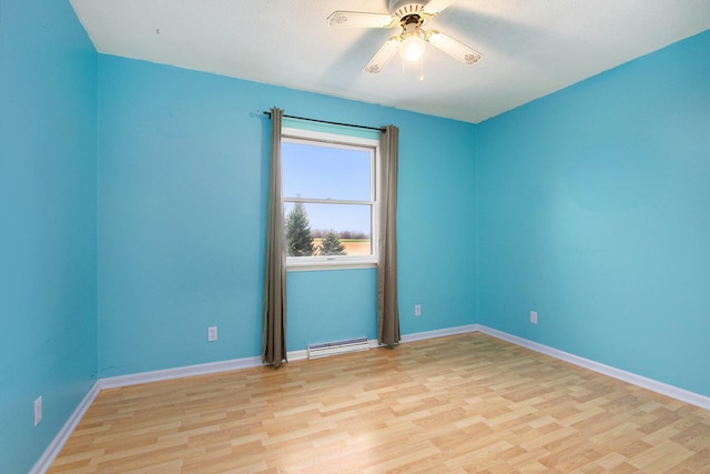 unfurnished room with light hardwood / wood-style floors, ceiling fan, and a baseboard heating unit