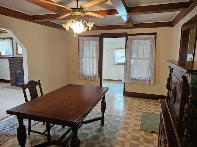 carpeted dining room with ceiling fan, beam ceiling, and coffered ceiling