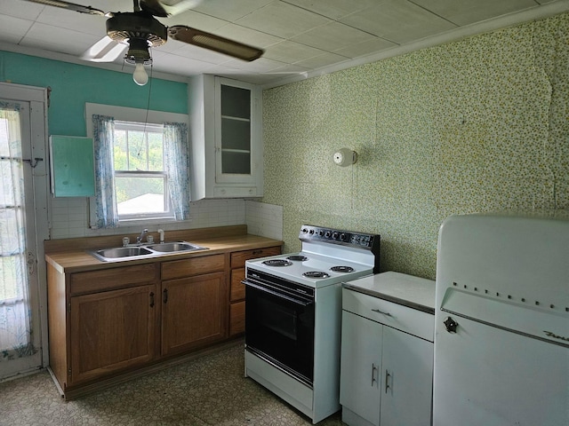 kitchen with backsplash, ceiling fan, sink, and white electric stove