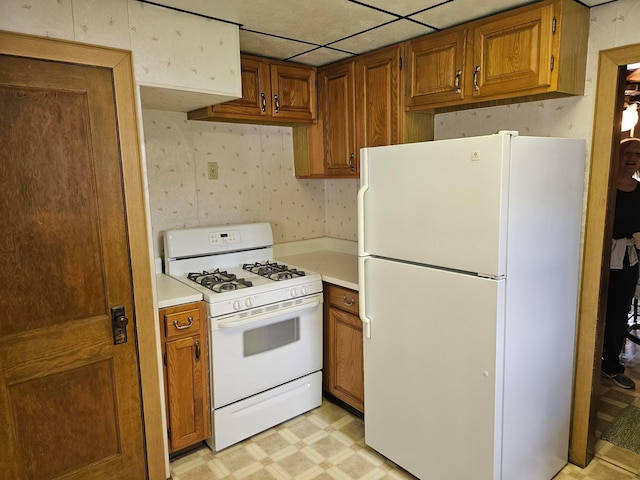 kitchen with a drop ceiling and white appliances