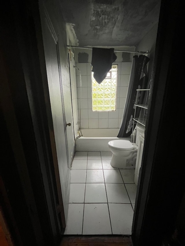 bathroom featuring tile patterned flooring, shower / bathtub combination with curtain, and toilet