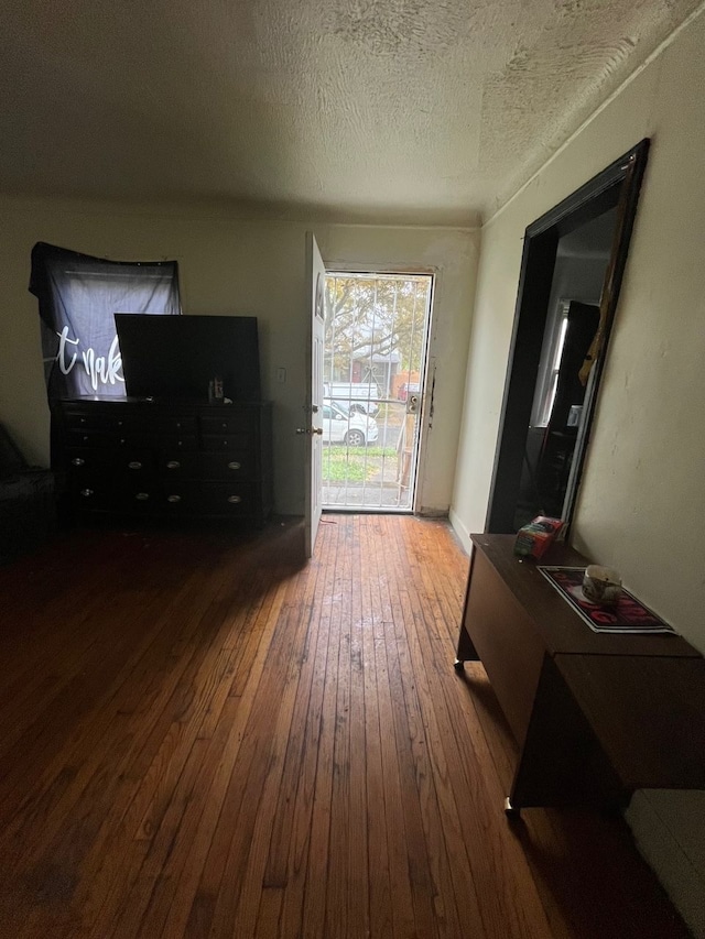 doorway to outside featuring a textured ceiling and hardwood / wood-style flooring