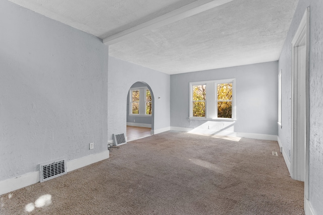 unfurnished living room with carpet flooring and a textured ceiling