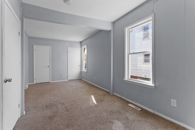 carpeted spare room featuring ornamental molding