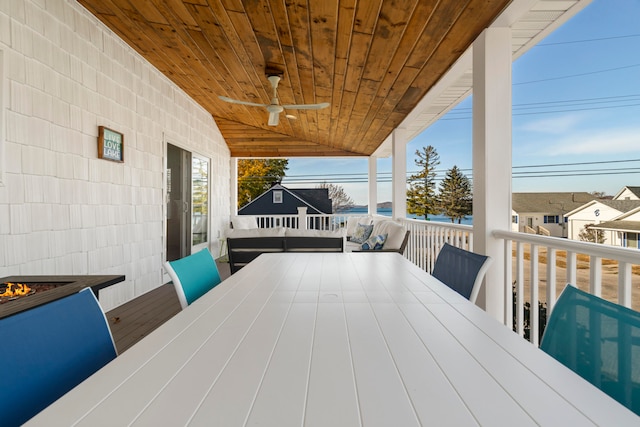 wooden deck with outdoor lounge area and ceiling fan