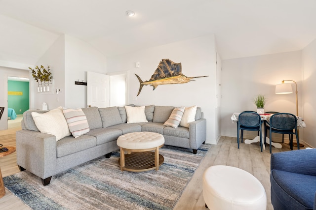 living room with light hardwood / wood-style flooring and vaulted ceiling