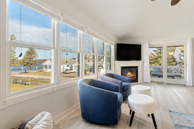 sunroom / solarium with ceiling fan, plenty of natural light, and lofted ceiling