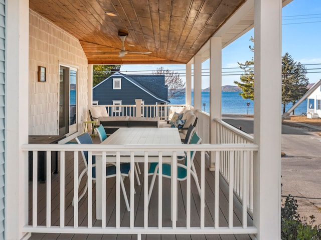 deck with ceiling fan and a water view