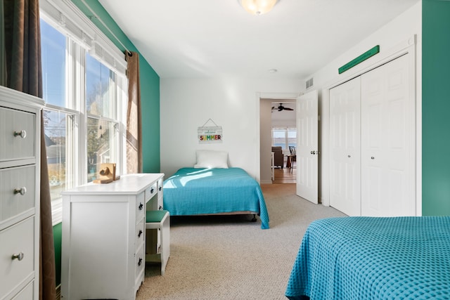 carpeted bedroom featuring a closet and multiple windows