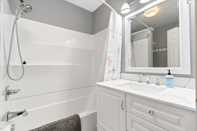 bathroom with shower / bath combination with curtain, vanity, and a textured ceiling