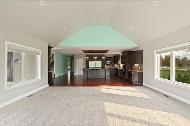 unfurnished living room featuring dark carpet and lofted ceiling