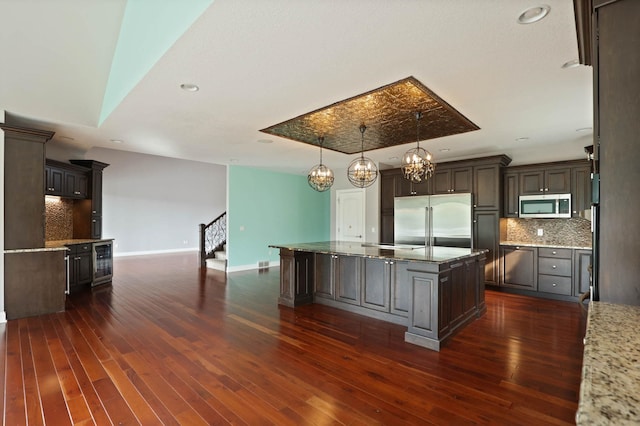 kitchen featuring appliances with stainless steel finishes, dark hardwood / wood-style floors, and a kitchen island