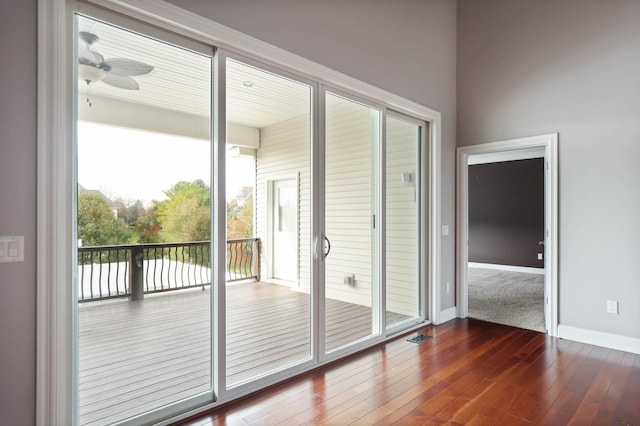 doorway to outside featuring ceiling fan and dark wood-type flooring