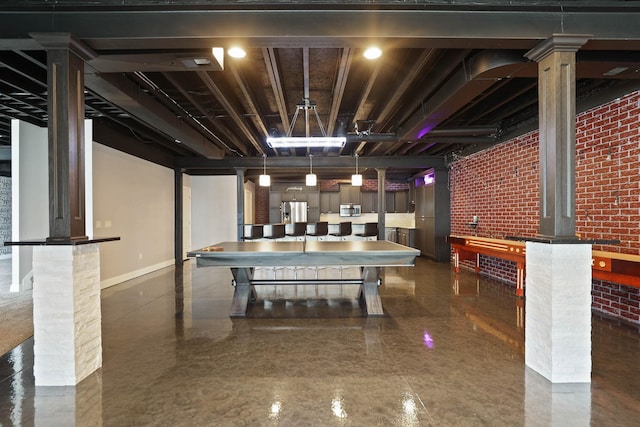 interior space featuring stainless steel fridge with ice dispenser and brick wall