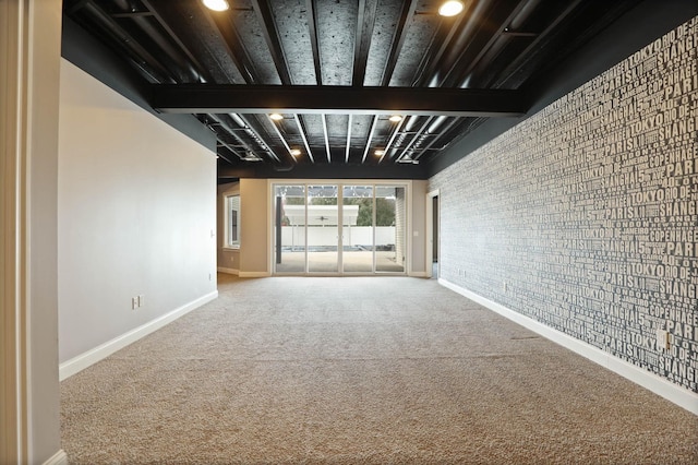 carpeted spare room featuring beamed ceiling