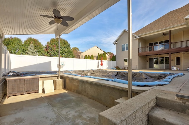 view of patio / terrace with a covered pool, a balcony, and ceiling fan