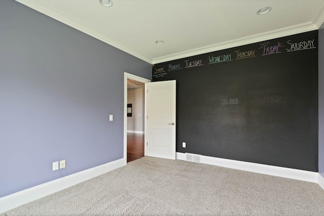 carpeted spare room with crown molding