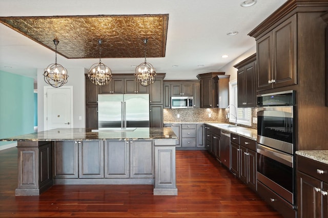 kitchen featuring a kitchen island, stainless steel appliances, and dark wood-type flooring