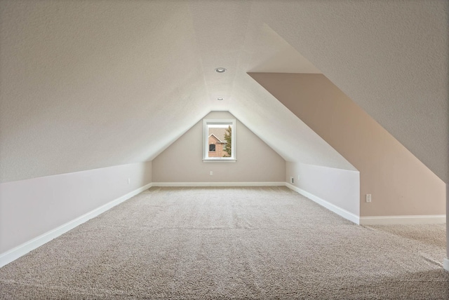 bonus room featuring carpet flooring, a textured ceiling, and lofted ceiling