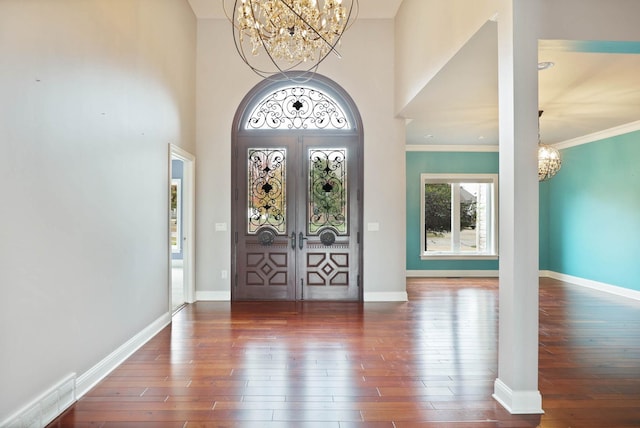 foyer entrance featuring french doors, dark hardwood / wood-style flooring, a high ceiling, and ornamental molding