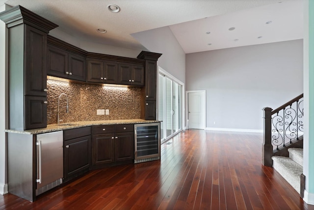 kitchen featuring dark brown cabinetry, stainless steel fridge, beverage cooler, and dark hardwood / wood-style floors