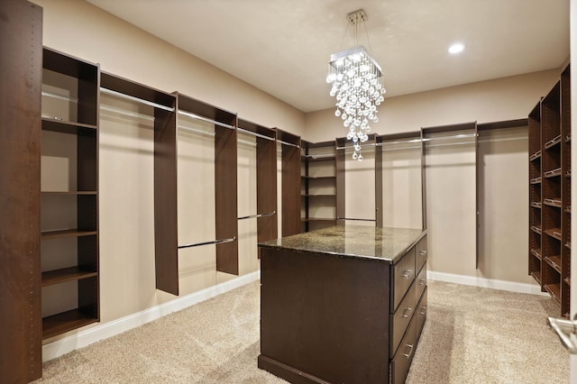 walk in closet with light colored carpet and an inviting chandelier