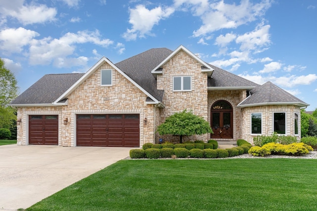 view of front of home with a front lawn, a garage, and french doors