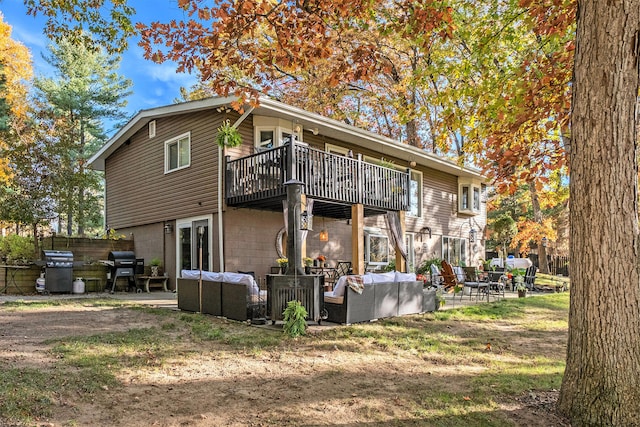 rear view of house with outdoor lounge area, a balcony, and a patio area