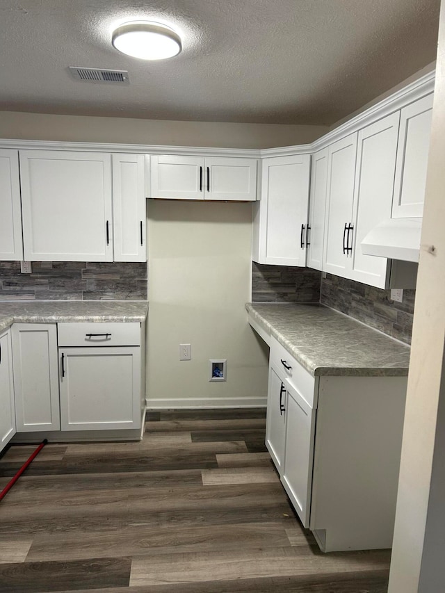 kitchen featuring white cabinets, dark hardwood / wood-style flooring, a textured ceiling, and tasteful backsplash