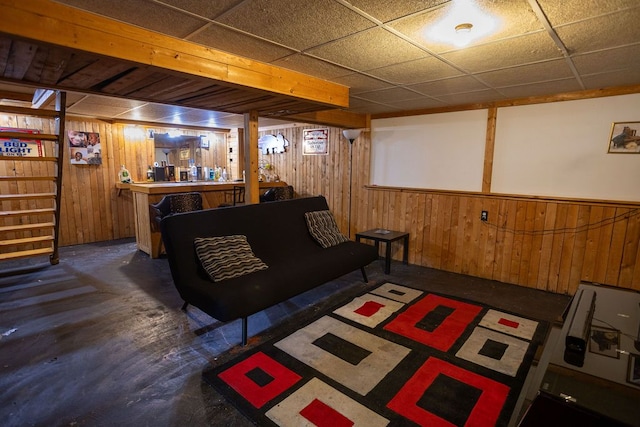 living room with wooden walls and a drop ceiling