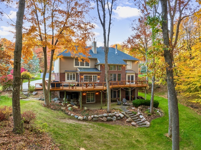 back of property with a lawn and a wooden deck