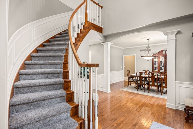 stairway featuring hardwood / wood-style floors and crown molding