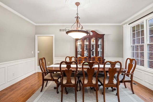 dining room featuring light wood-type flooring and ornamental molding