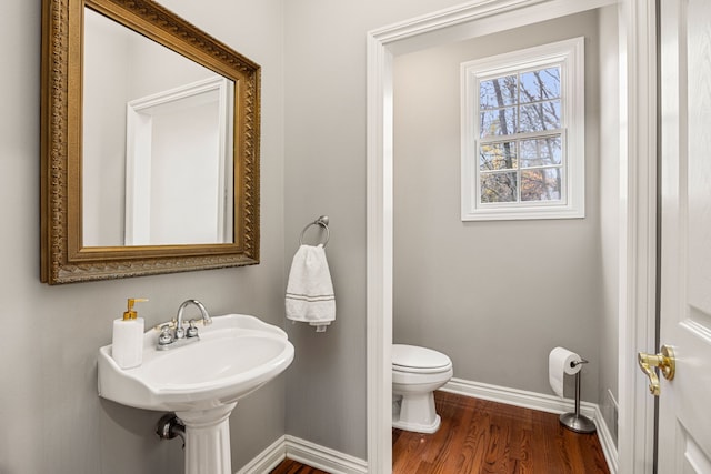 bathroom with hardwood / wood-style flooring, toilet, and sink