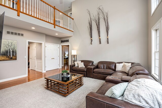 living room with plenty of natural light, hardwood / wood-style floors, and a high ceiling