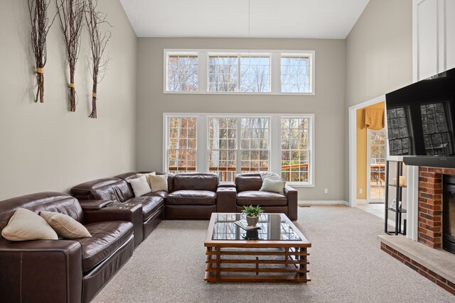 living room featuring carpet, a fireplace, and high vaulted ceiling