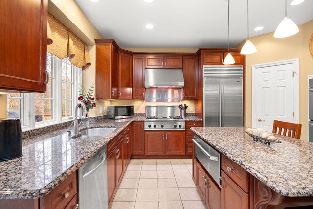 kitchen featuring a breakfast bar, a center island, sink, light tile patterned floors, and stainless steel appliances