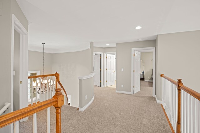 corridor with light carpet and a notable chandelier