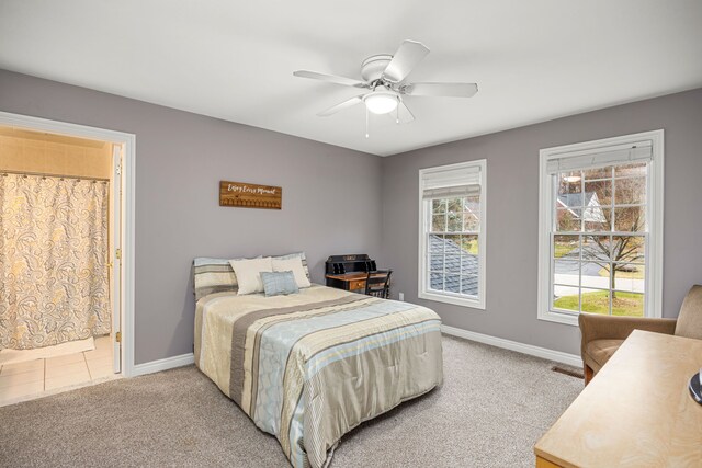 carpeted bedroom featuring ensuite bathroom and ceiling fan