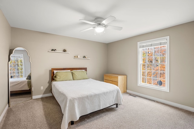 bedroom with multiple windows, ceiling fan, and carpet floors