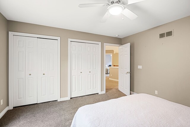 bedroom featuring carpet, ceiling fan, and multiple closets