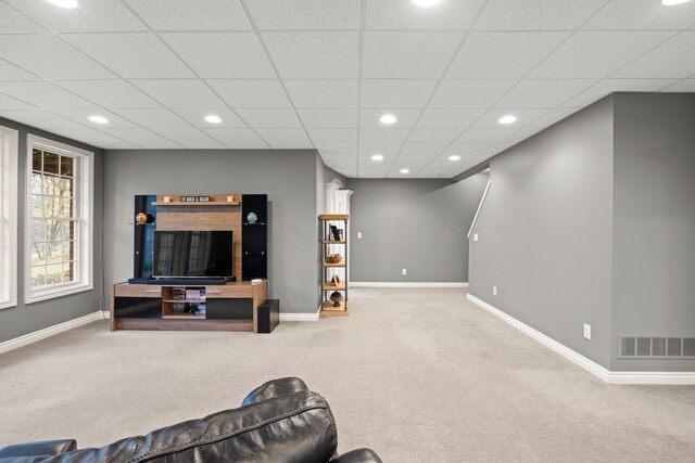 carpeted living room with a paneled ceiling