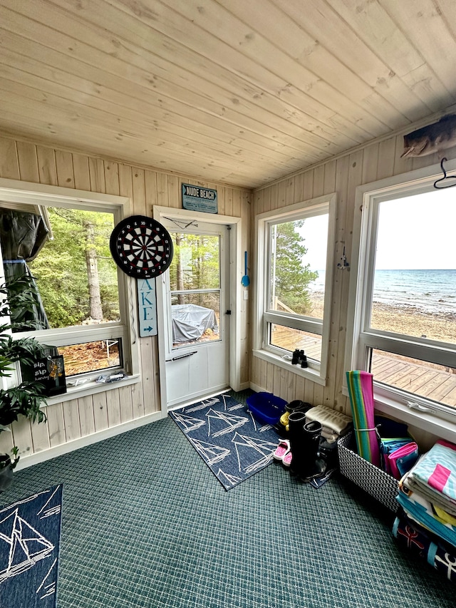 sunroom / solarium featuring a water view and wooden ceiling