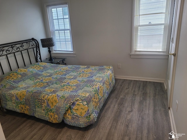 bedroom with dark hardwood / wood-style flooring